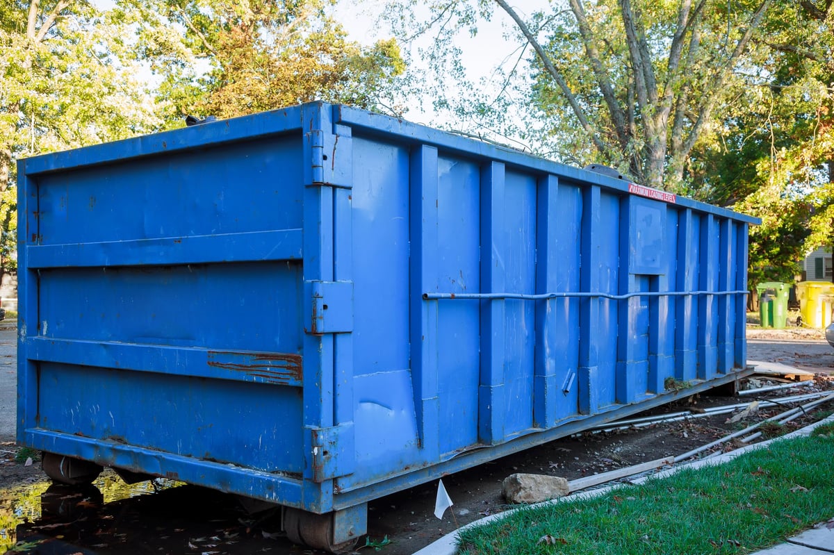 A loaded dumpster near a home renovation construction site